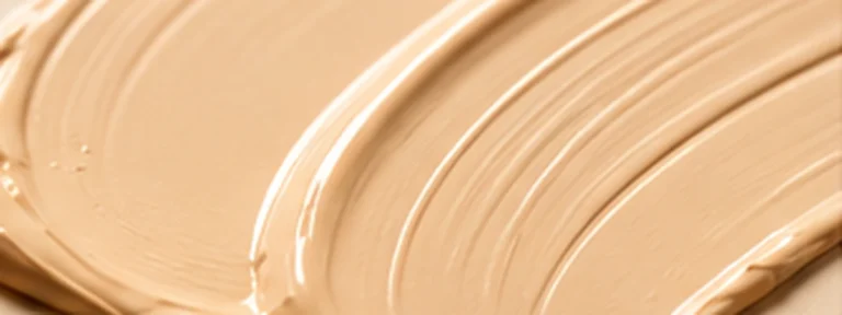 Smooth beige satin base texture with a softly polished cosmetic finish.