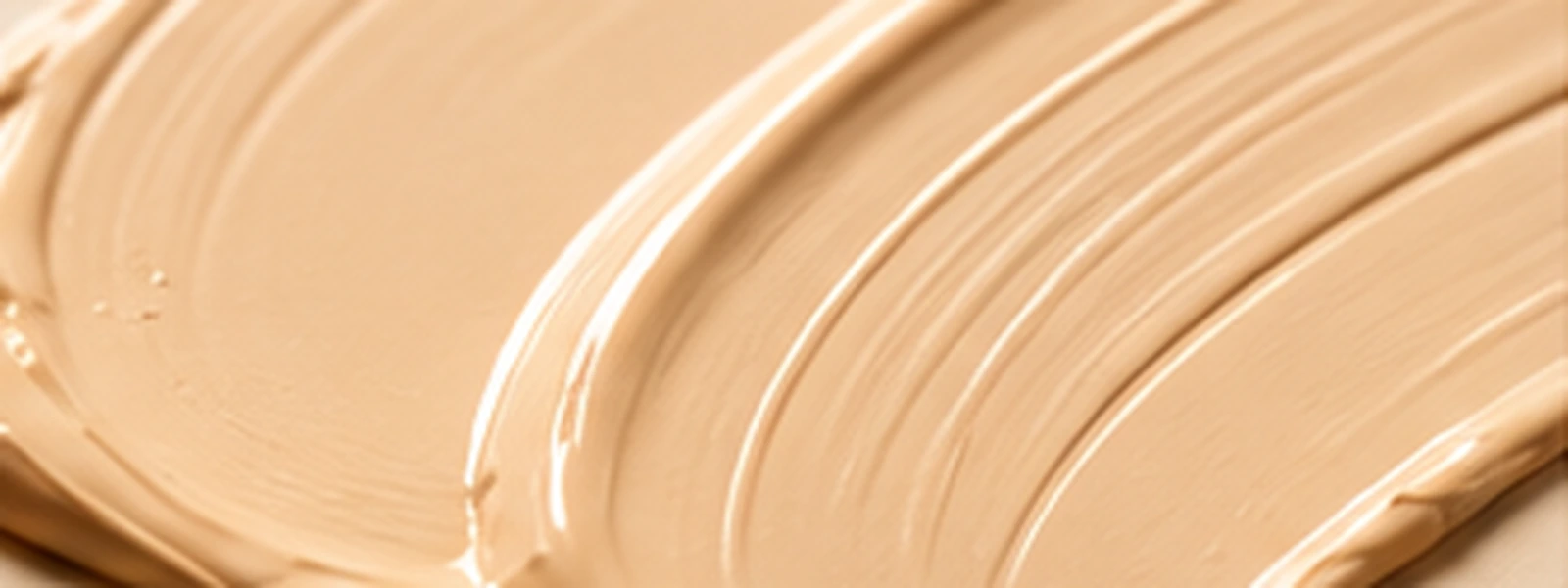 Smooth beige satin base texture with a softly polished cosmetic finish.