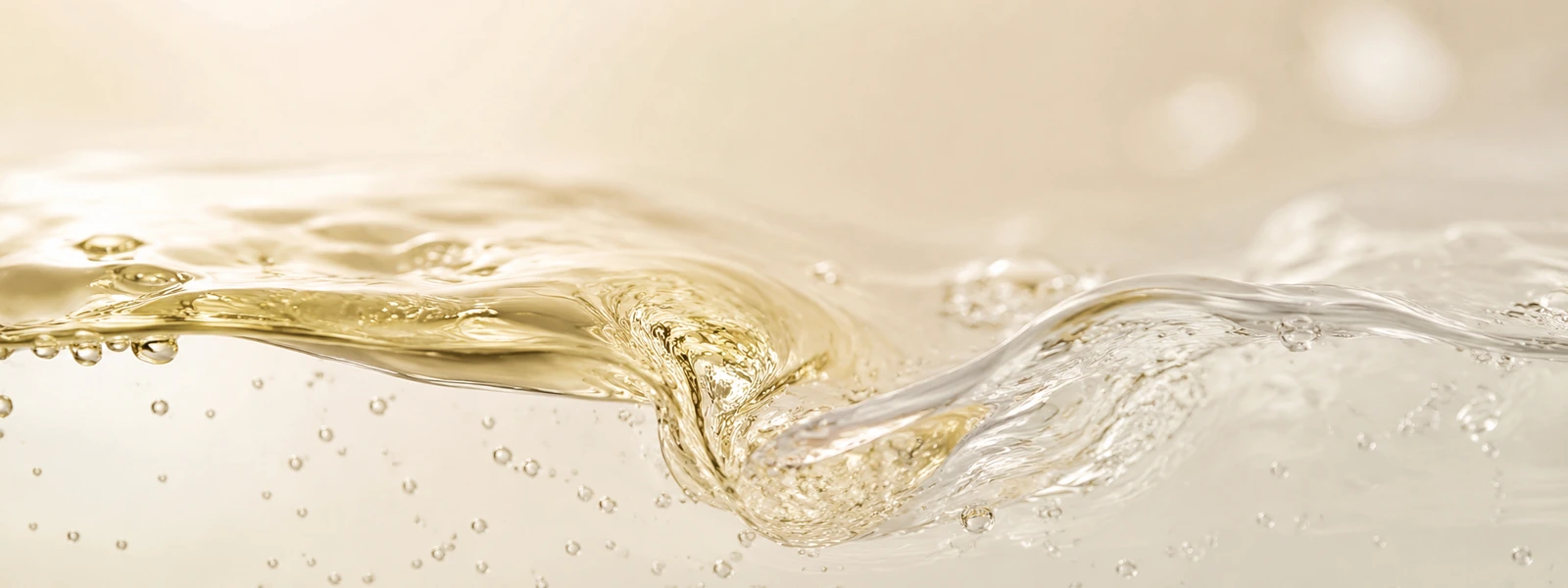 Thin golden cleansing oil swirling into a clear watery cleanser layer on warm ivory.