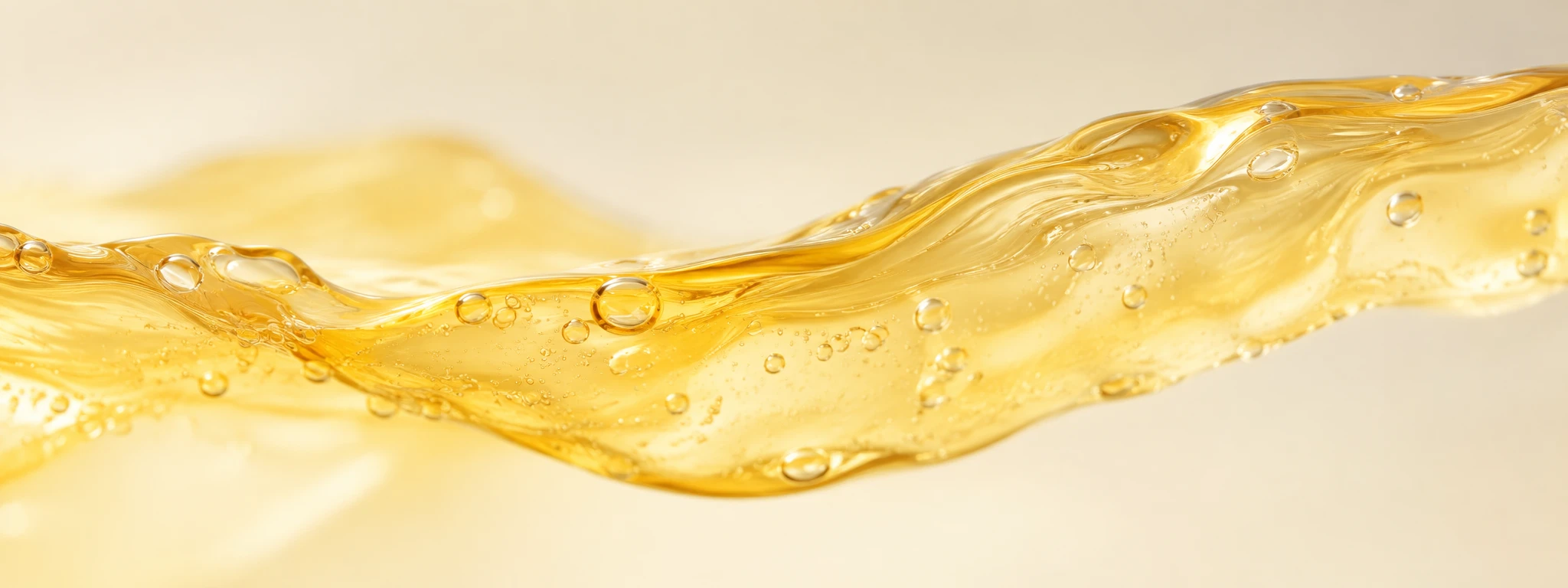 Golden translucent vitamin C serum in a smooth pouring ribbon, warm amber tones.