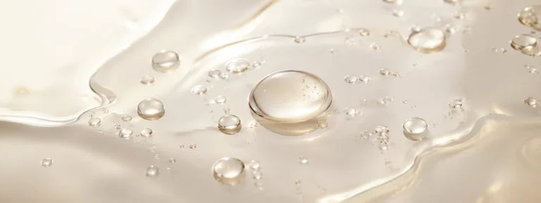 Luminous pale-gold gel with suspended bubbles catching bright light.