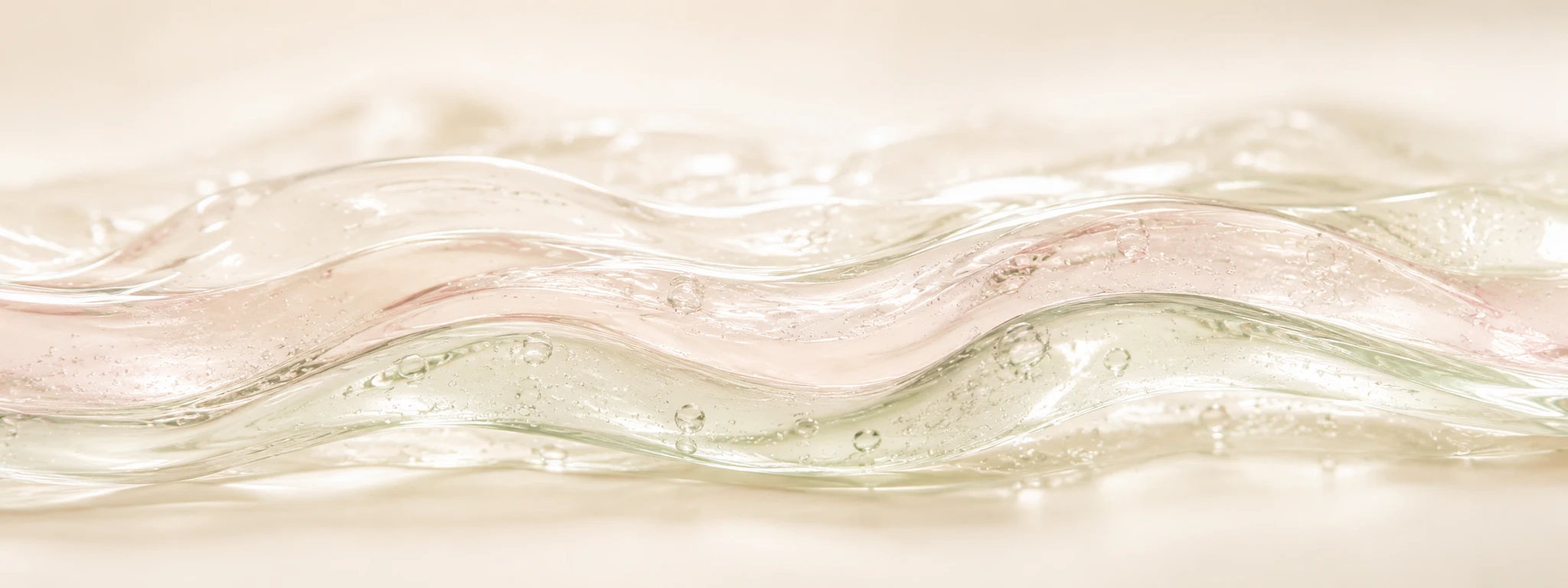 Three translucent ribbon layers in sage, blush, and ivory tints folding together, representing layered skincare textures.